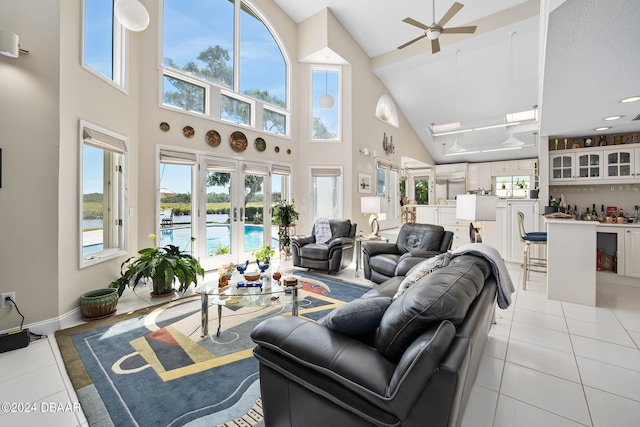 living room with ceiling fan, light tile patterned floors, a high ceiling, and french doors