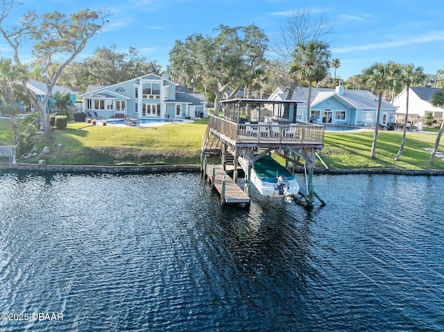 dock area featuring a deck with water view, a patio area, and a lawn