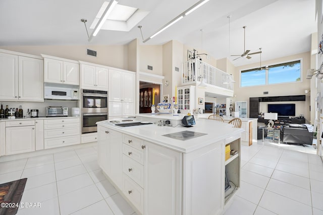 kitchen featuring white cabinetry, light tile patterned flooring, white appliances, and high vaulted ceiling