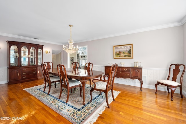 dining area with a notable chandelier, light wood-type flooring, and ornamental molding