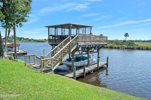 view of dock featuring a lawn and a water view