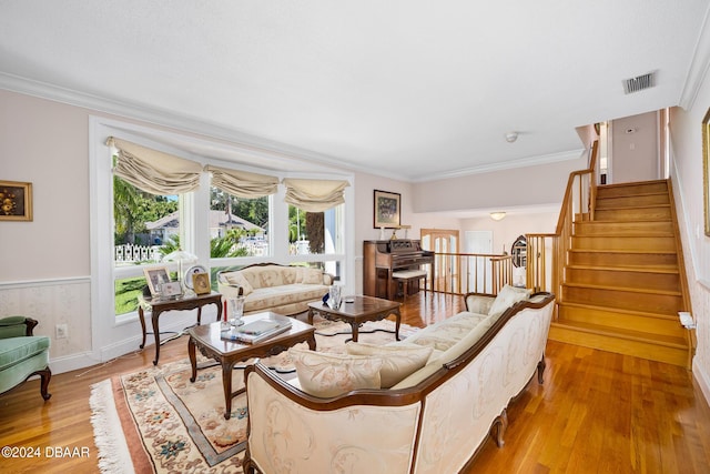 living room with light wood-type flooring and ornamental molding