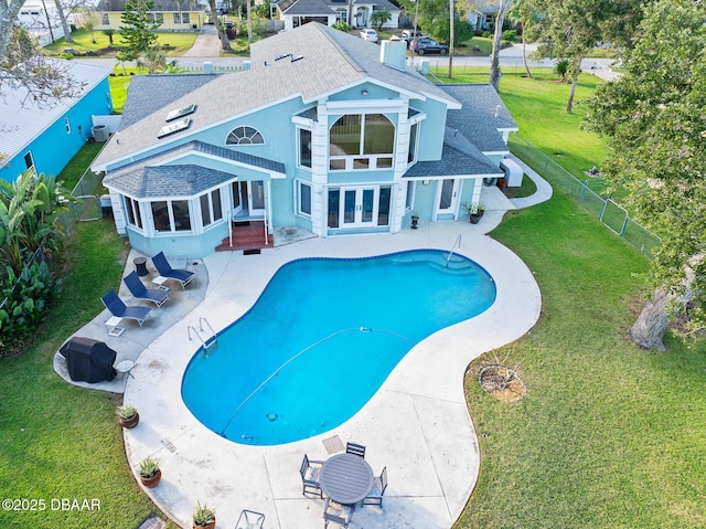 view of pool featuring french doors, a patio, a lawn, and a sunroom