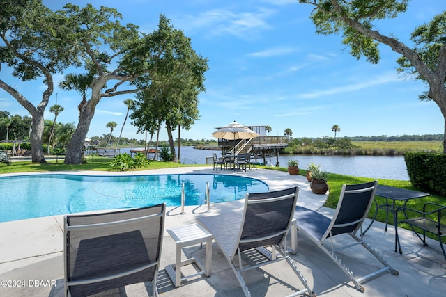 view of pool featuring a water view and a patio