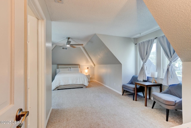 carpeted bedroom featuring baseboards, visible vents, vaulted ceiling, and a textured ceiling