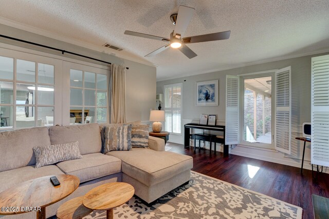 living room with visible vents, ceiling fan, wood finished floors, crown molding, and a textured ceiling