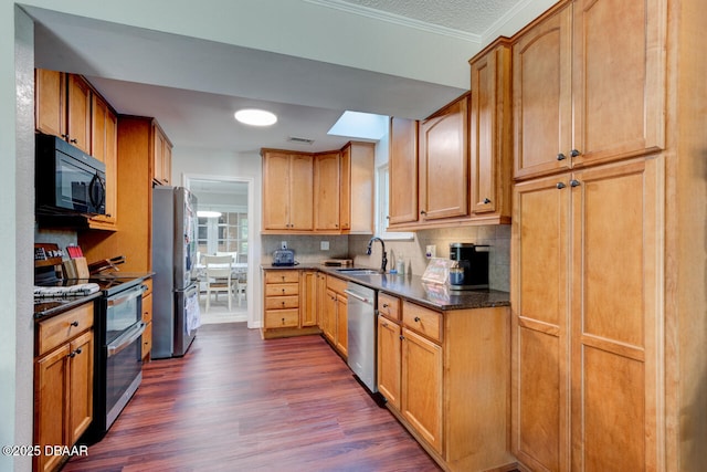 kitchen featuring visible vents, decorative backsplash, appliances with stainless steel finishes, dark wood-type flooring, and a sink