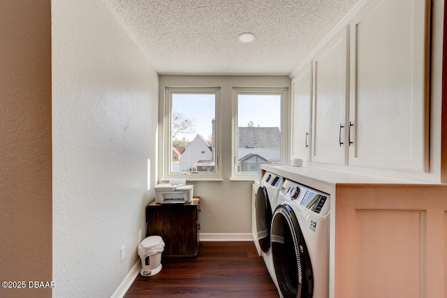 washroom with a textured wall, dark wood-type flooring, a textured ceiling, separate washer and dryer, and baseboards