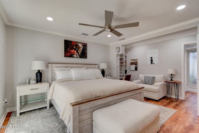 bedroom featuring a textured ceiling, light wood-style flooring, visible vents, and crown molding