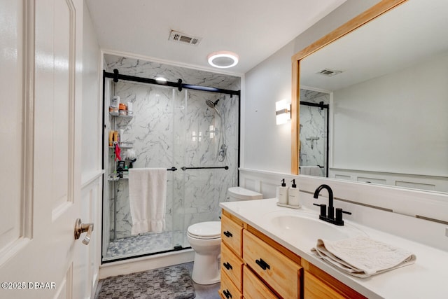 bathroom with toilet, a marble finish shower, visible vents, and vanity