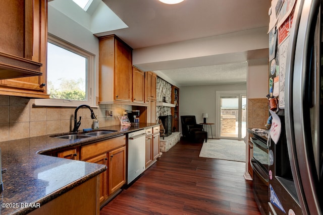 kitchen with stainless steel appliances, a wealth of natural light, a sink, and dark wood-style floors