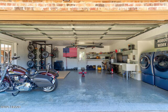 garage featuring independent washer and dryer and a sink