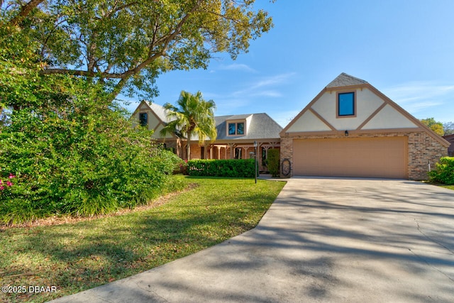 tudor-style house with a garage, a front yard, brick siding, and driveway