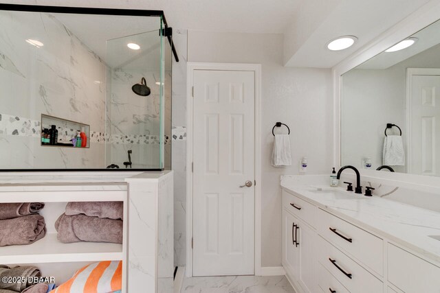 bathroom featuring recessed lighting, marble finish floor, vanity, and a marble finish shower