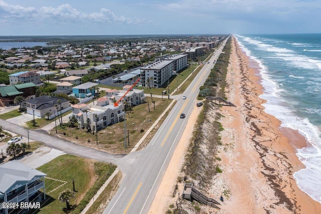 bird's eye view with a water view and a beach view