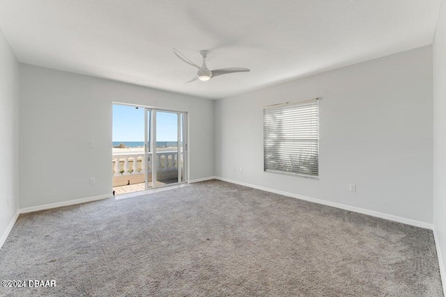 carpeted spare room with plenty of natural light, ceiling fan, and a water view