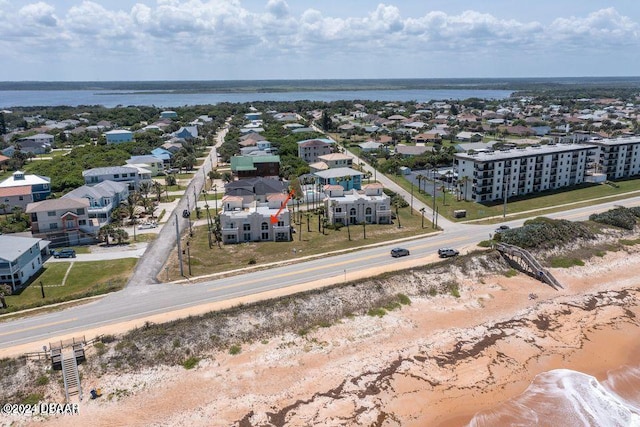 birds eye view of property with a water view and a beach view