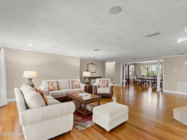 living room with crown molding and light hardwood / wood-style flooring