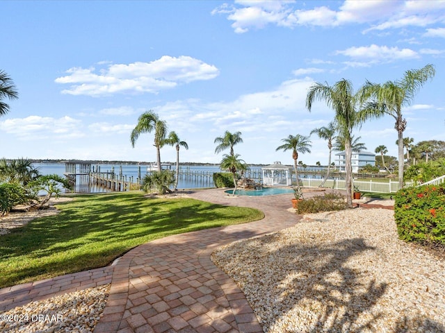 view of home's community featuring a boat dock, a water view, a yard, and a pool