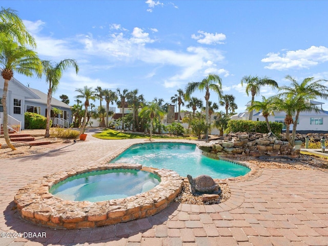 view of swimming pool with an in ground hot tub