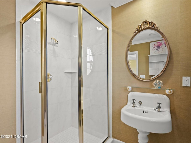 bathroom featuring sink, an enclosed shower, and ornamental molding