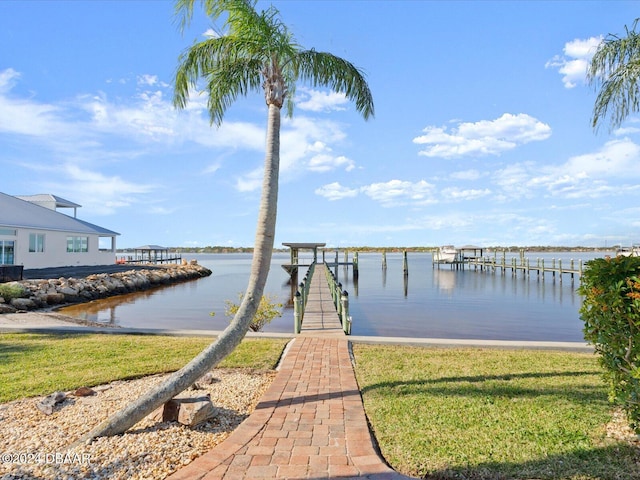 dock area featuring a lawn and a water view