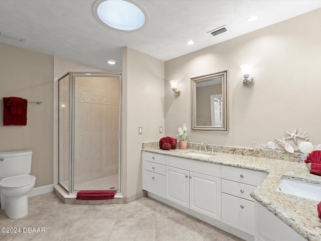 bathroom with tile patterned floors, a shower with door, vanity, and toilet