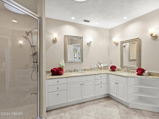 bathroom featuring tile patterned flooring, vanity, and a shower with door