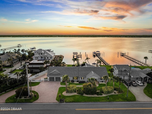 aerial view at dusk featuring a water view