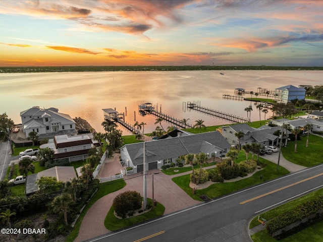 aerial view at dusk featuring a water view