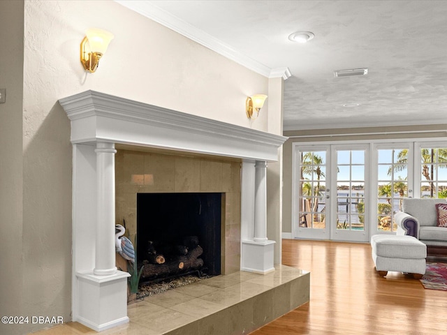 living room featuring a fireplace, french doors, wood-type flooring, and ornamental molding