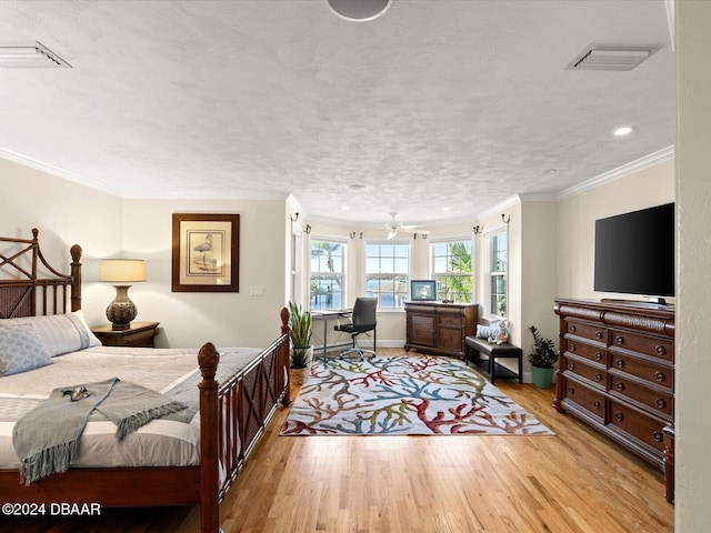 bedroom featuring crown molding, a textured ceiling, and light wood-type flooring