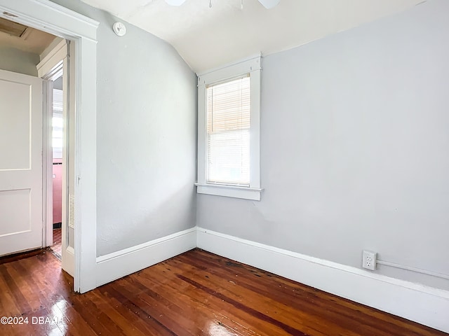 unfurnished room with vaulted ceiling and dark hardwood / wood-style flooring