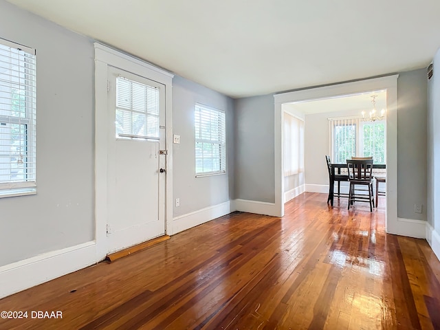 entryway with hardwood / wood-style floors and an inviting chandelier