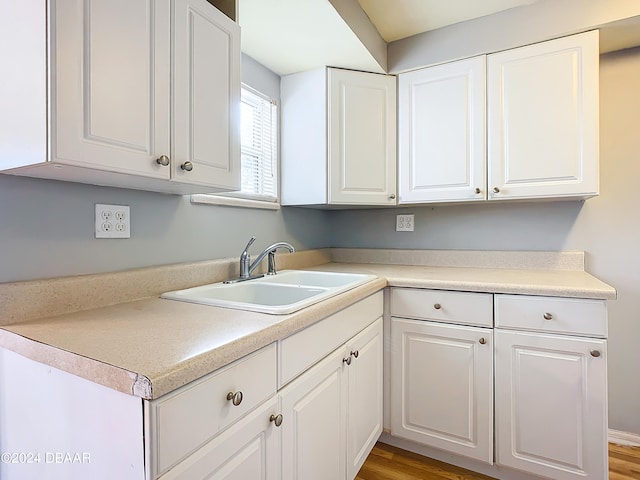 kitchen with sink, white cabinetry, and hardwood / wood-style floors