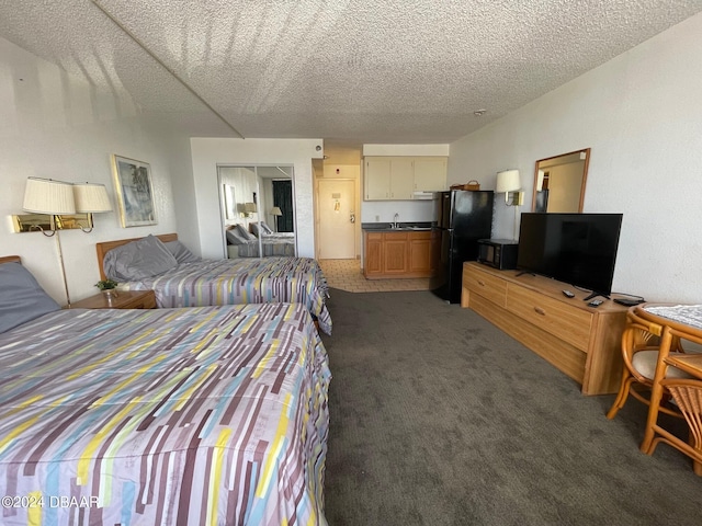 2043 S Atlantic Ave Unit 304, Daytona Beach Shores, FL 32118 - carpeted bedroom with freestanding refrigerator, a textured ceiling, a closet, and a sink