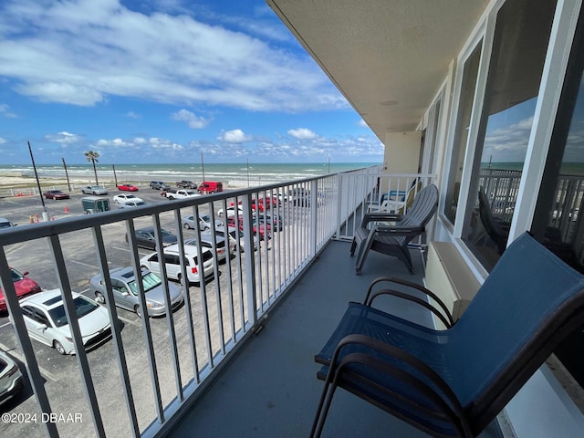 balcony with a water view and a beach view