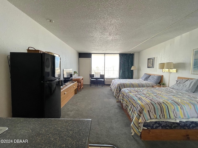 2043 S Atlantic Ave Unit 304, Daytona Beach Shores, FL 32118 - bedroom featuring freestanding refrigerator, a textured ceiling, carpet floors, and a desk