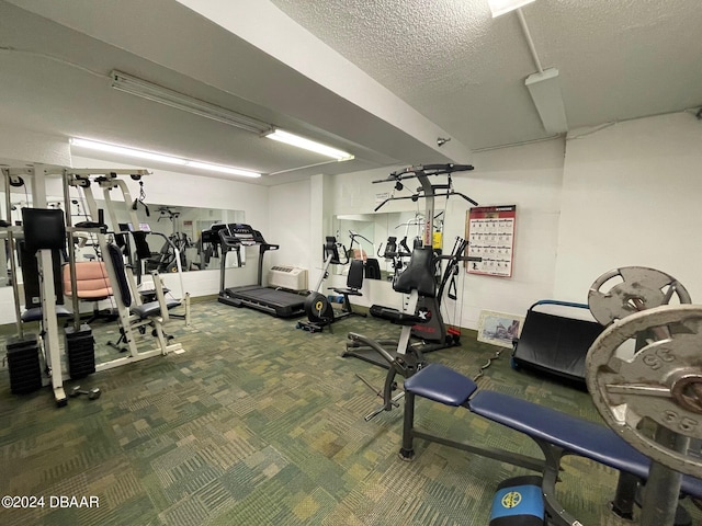 gym featuring carpet floors and a textured ceiling