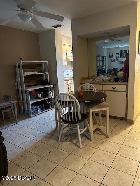 dining space featuring visible vents, light tile patterned flooring, and a ceiling fan