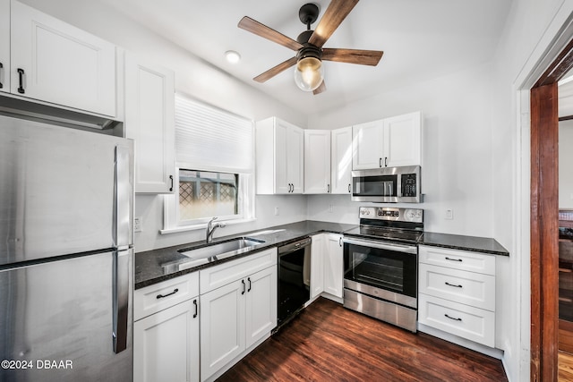 kitchen with stainless steel appliances, white cabinetry, dark wood-type flooring, and sink