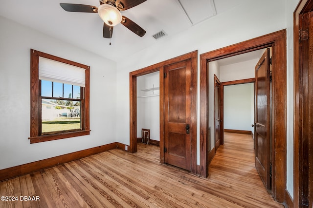 unfurnished bedroom featuring a closet, light hardwood / wood-style floors, and ceiling fan