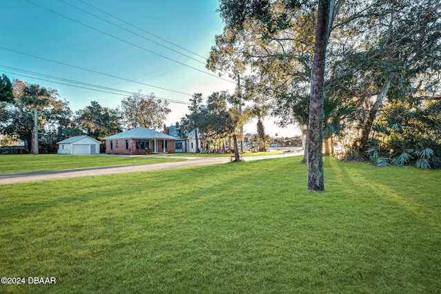 view of yard featuring a garage and an outbuilding