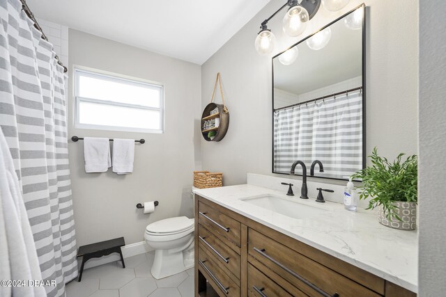 bathroom with tile patterned flooring, vanity, and toilet