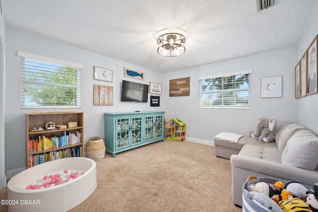 recreation room featuring carpet flooring and a textured ceiling