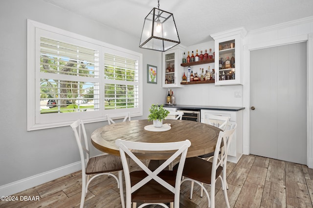 dining room with bar, light hardwood / wood-style floors, and wine cooler