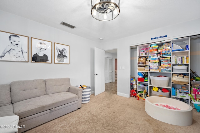 recreation room with carpet and a textured ceiling