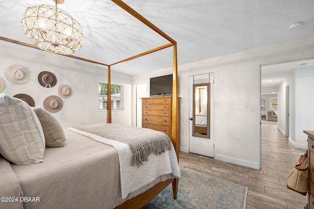 bedroom featuring a textured ceiling and light hardwood / wood-style flooring