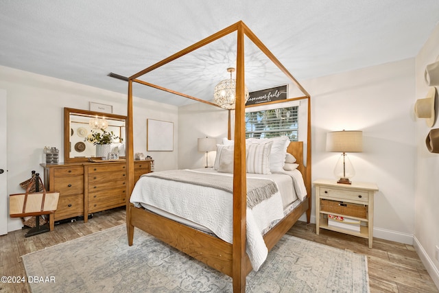 bedroom featuring hardwood / wood-style floors and a chandelier