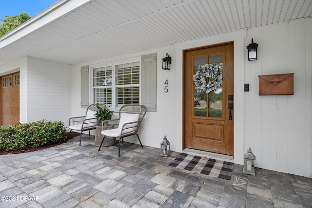 view of exterior entry with a garage and covered porch